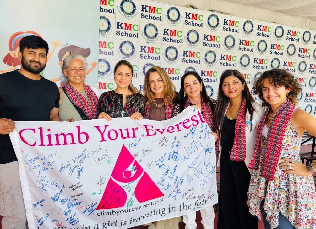 The Climb Your Everest team holding a signed banner at KMC School in Kathmandu