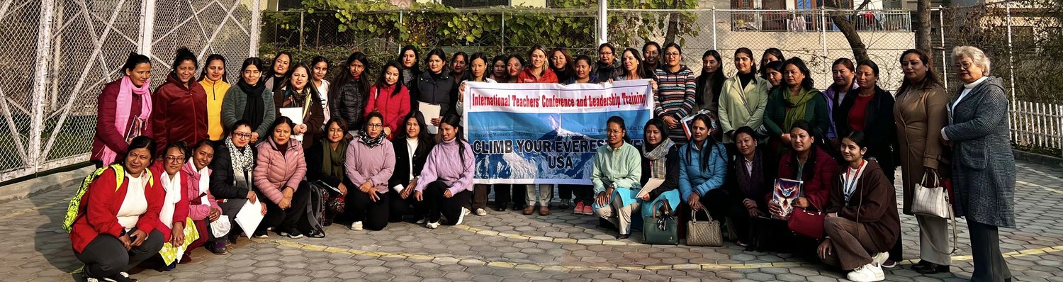 Teachers and trainers gathered around the Climb Your Everest conference banner