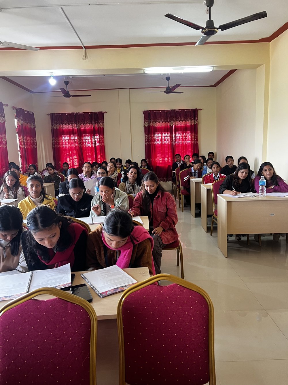 A hall full of young women working through the course material at their desks