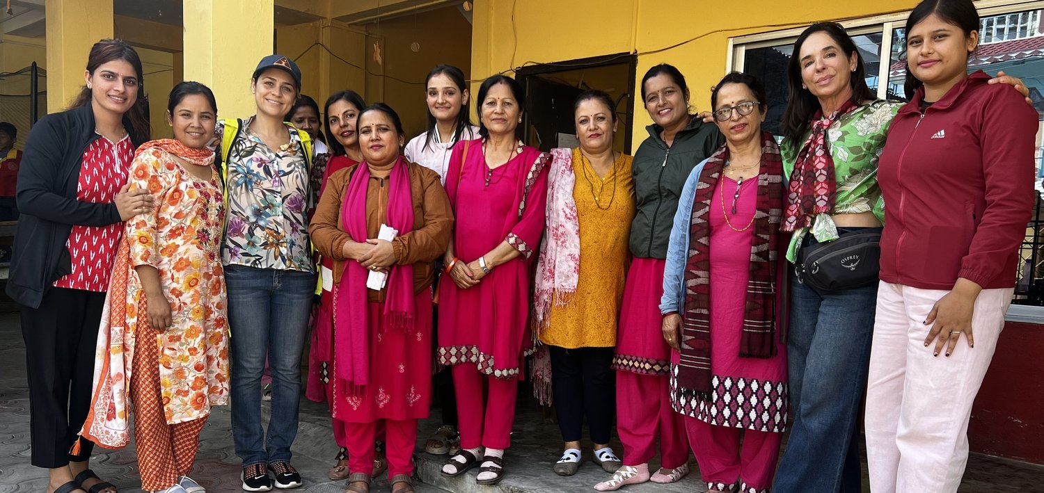 A group of women standing together outside a community building in Nepal